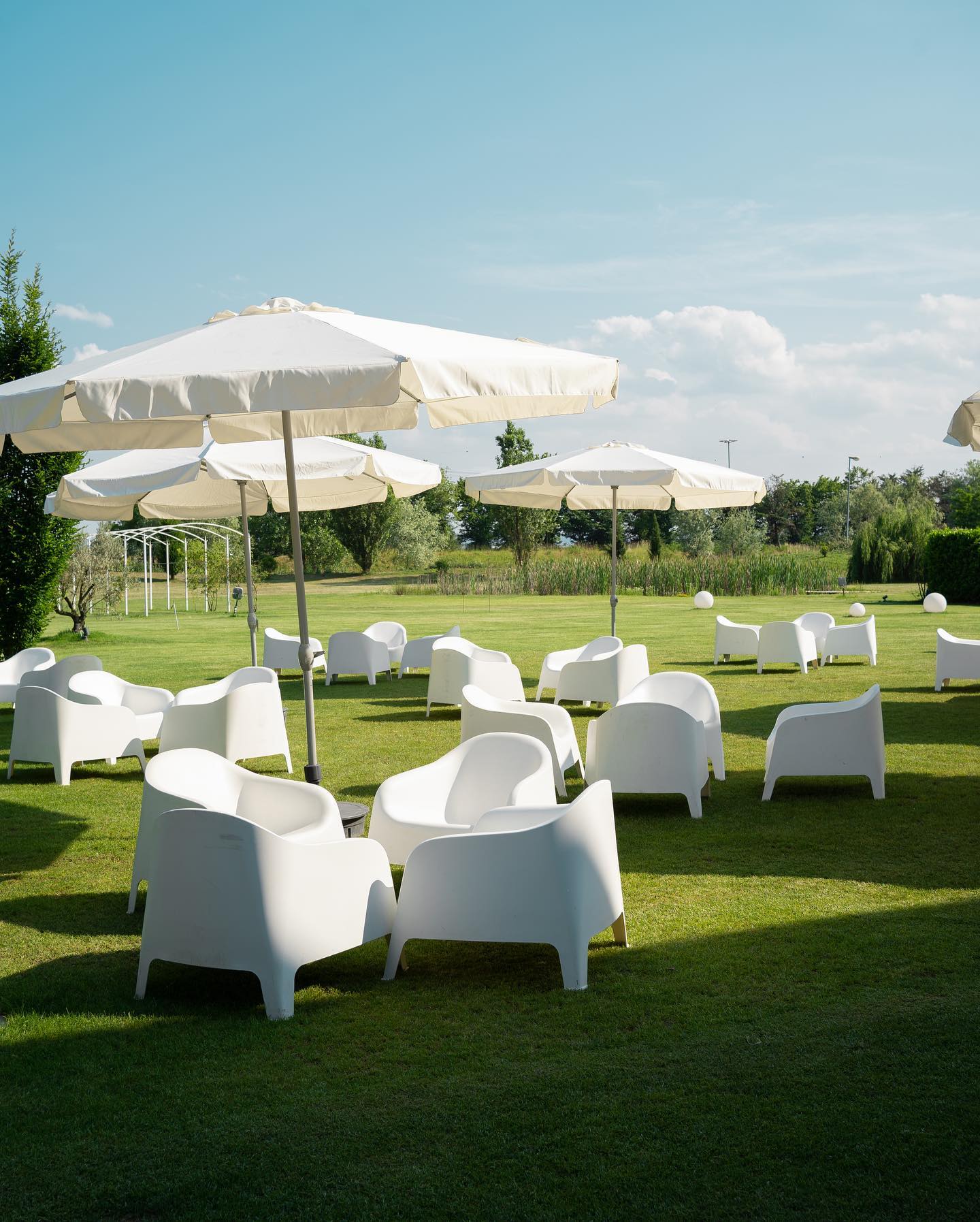 Giardino esterno dell'Hotel Rondissone con ombrelloni e poltrone